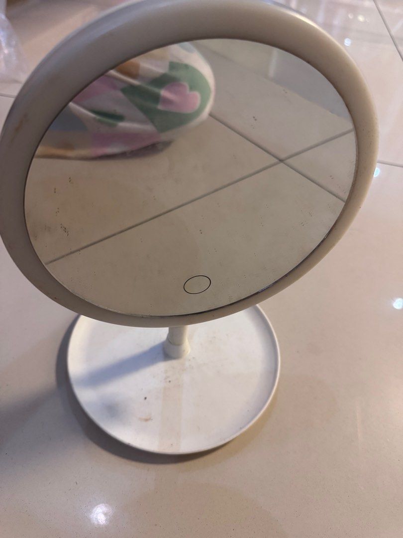 White Makeup Mirror no lights desk vanity mirror (Category: Makeup) located in Manila. Submitted by decluterthings888 (Listing ID 1411196064, Image 2). Description: - White makeup mirror - Round, illuminated mirror surface - Touch button control - Tiltable mirror - Circular base with a small tray.