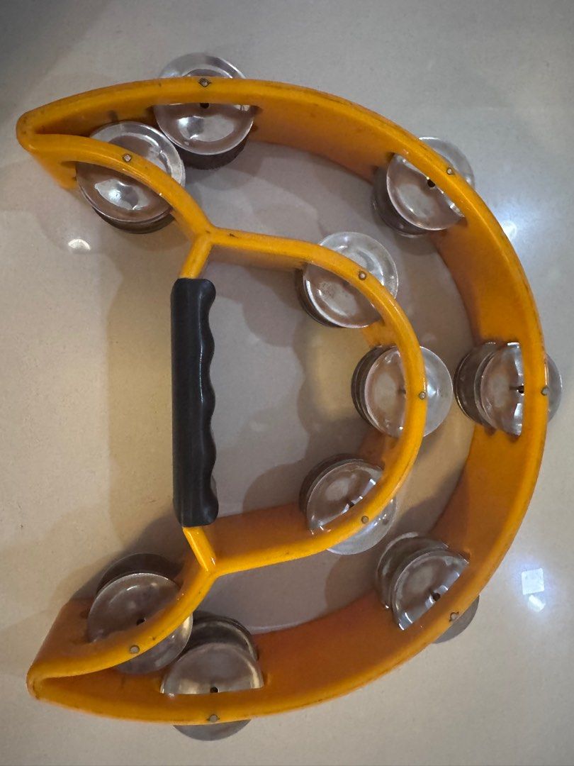Yellow Tambourine with Handle (Category: Musical Instruments) located in Manila. Submitted by decluterthings888 (Listing ID 1411208087, Image 1). Description: - Bright yellow tambourine - Black handle for easy grip - Equipped with metal jingles - Hand-held design - Suitable for performances or recreational use.