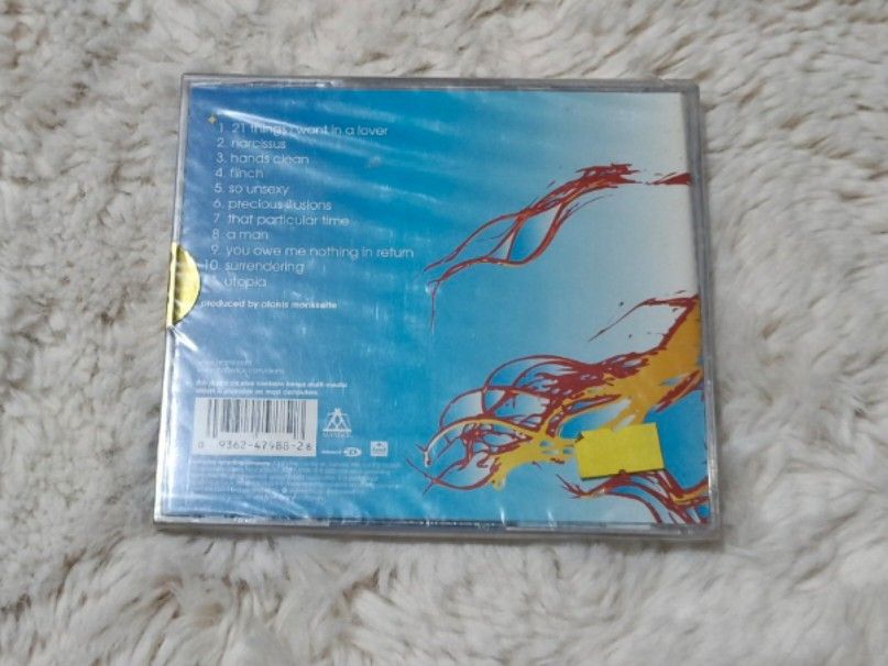 Alanis Morissette Under Rug Swept CD (Category: CDs & DVDs) located in Quezon City. Submitted by kevinfuentes0219 (Listing ID 1411058255, Image 2). Description: - Alanis Morissette "Under Rug Swept" CD - Still sealed in original packaging - Features hit singles: "Hands Clean" and "Precious Illusions" - Includes tracks like "21 Things" and "So Unsexy".
