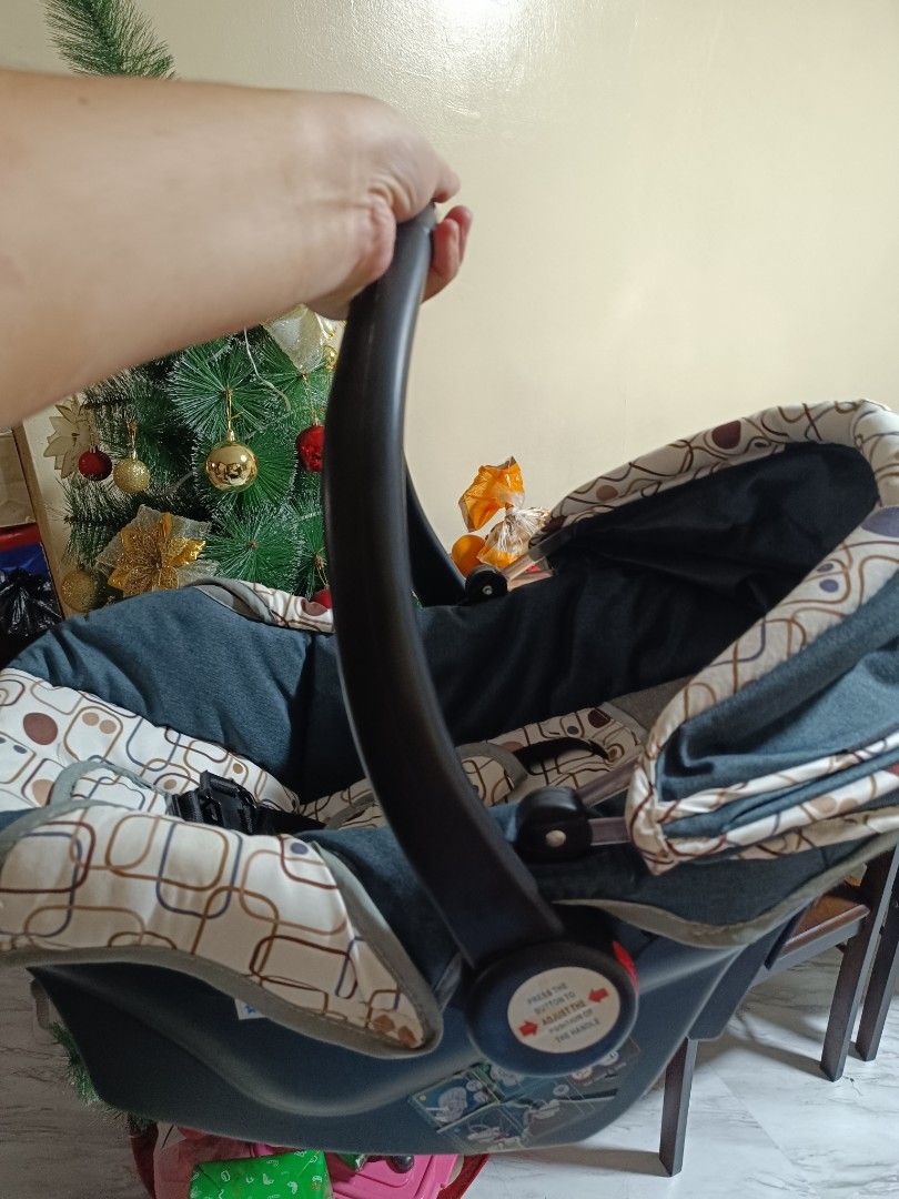 Baby Car Seat (Category: Car Seats) located in Makati City. Submitted by billyun (Listing ID 1411303556, Image 2). Description: - Stylish baby car seat - Almost new - Dark blue and beige patterned fabric - Includes a carrying handle - Features a sunshade - Equipped with a safety harness.