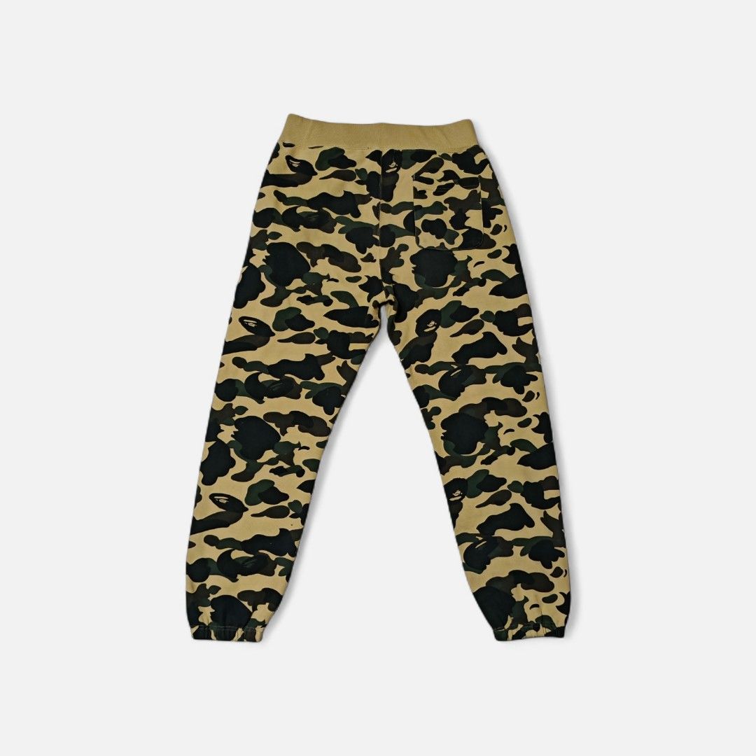 BAPE Shark Camo Sweatpants - Size L (Category: Joggers) located in Makati City. Submitted by marquez25 (Listing ID 1411303536, Image 2). Description: - Authentic BAPE sweatpants - Iconic shark face design - Camouflage pattern (yellow, green, black) - Size: L - BAPE logo on tag - Drawstring waistband - Cuffed ankles - Camo pattern on back.