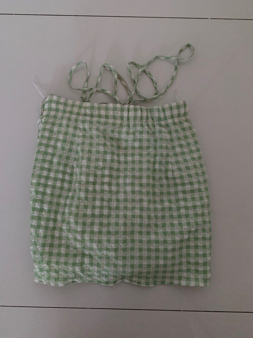 Bershka Skirt (Category: Dresses) located in Pasig City. Submitted by wasabii14 (Listing ID 1411289443, Image 2). Description: - Bershka skirt - Green and white gingham pattern - Size XS - Ruched bodice - Fitted silhouette - Minor stains present - Perfect for casual or summer wear.