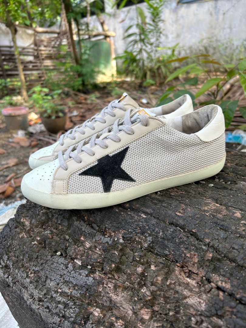 Golden Goose Superstar Sneakers (Category: Sneakers) located in Iloilo. Submitted by resellmpg (Listing ID 1411333202, Image 3). Description: Golden Goose Superstar sneakers in beige and black. Features a mesh upper with a leather star detail on the side. The sneakers have a lace-up closure and a rubber sole. The brand name is visible on the side of the shoe. The sole is a light brown color..
