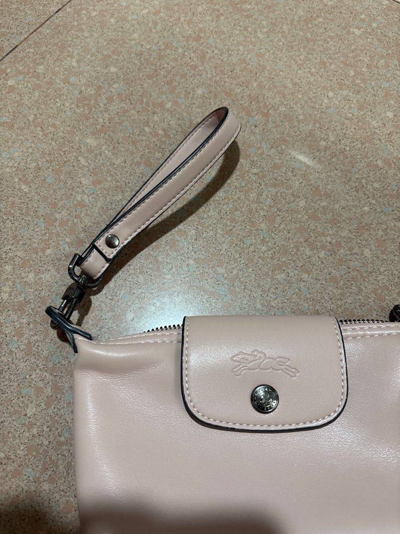Longchamp Le Pliage Cuir Clutch (Category: Luxury Bags & Wallets) located in Taguig. Submitted by passionfashion (Listing ID 1411331970, Image 2). Description: - Authentic Longchamp Le Pliage Cuir clutch - Soft pink color - Includes wrist strap - Flap closure with Longchamp logo - Interior with patterned lining - Zipper closure - Made in France - Perfect for everyday use - Bought from Japan Pasabuy Selling preloved pieces in good condition 💕 Neg