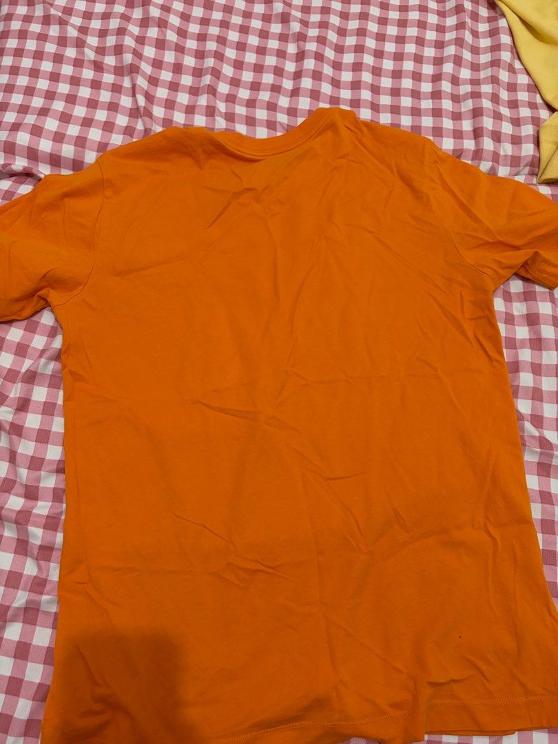 Nike Just Do It Tee - Orange (Category: Tshirts & Polo Shirts ) located in Mandaluyong City. Submitted by getbounced (Listing ID 1411329927, Image 3). Description: Orange Nike t-shirt featuring the iconic "JUST DO IT" slogan. The shirt has a small Nike logo on the front. It is a size S. Made in China. The tag also shows the style code BV7663-873. The shirt's measurements are approximately 25 inches in length and 20 inches in width..