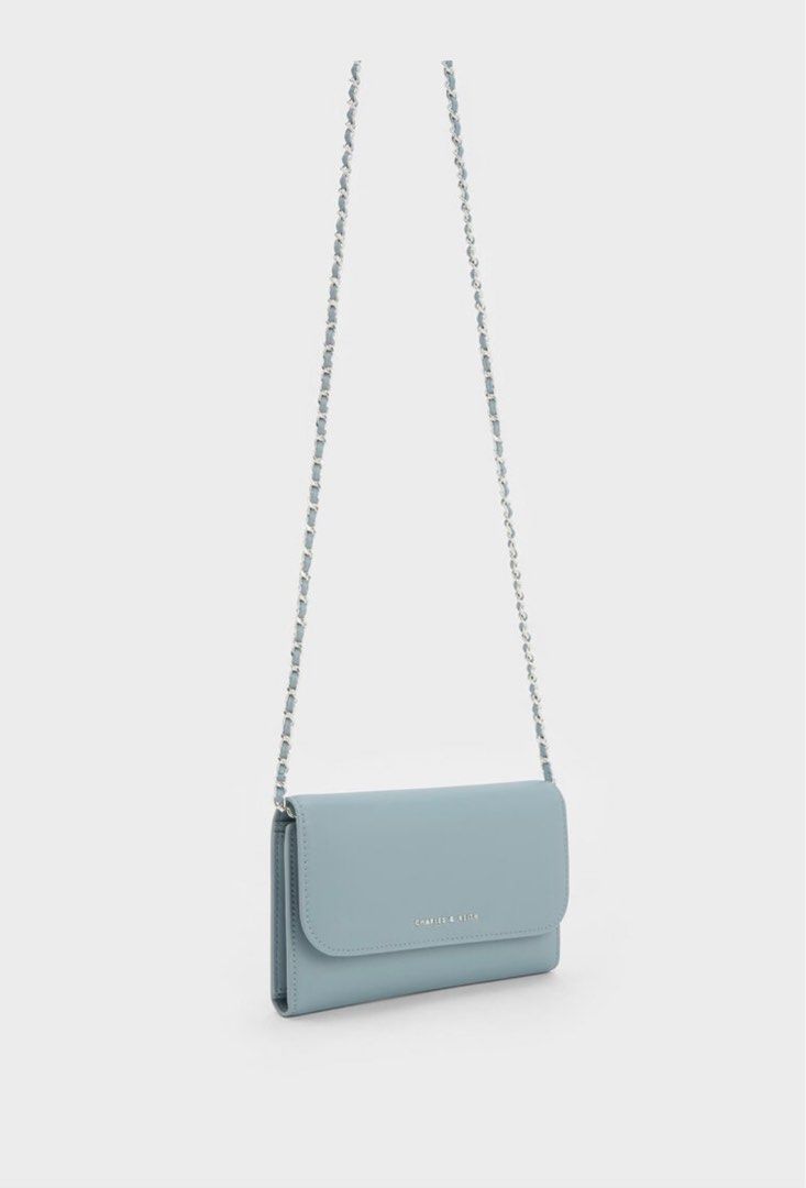 Charles & Keith Front Flap Long Wallet - Slate Blue (Category: Luxury Bags & Wallets) located in Iloilo. Submitted by pochuu (Listing ID 1411395063, Image 3). Description: - Charles & Keith wallet bag in slate blue - Features a stylish chain strap - Multiple compartments for organization - Includes card slots and a zippered pocket - Secure magnetic closure - Brand logo visible on the front - Comes with dust bag and original tags.