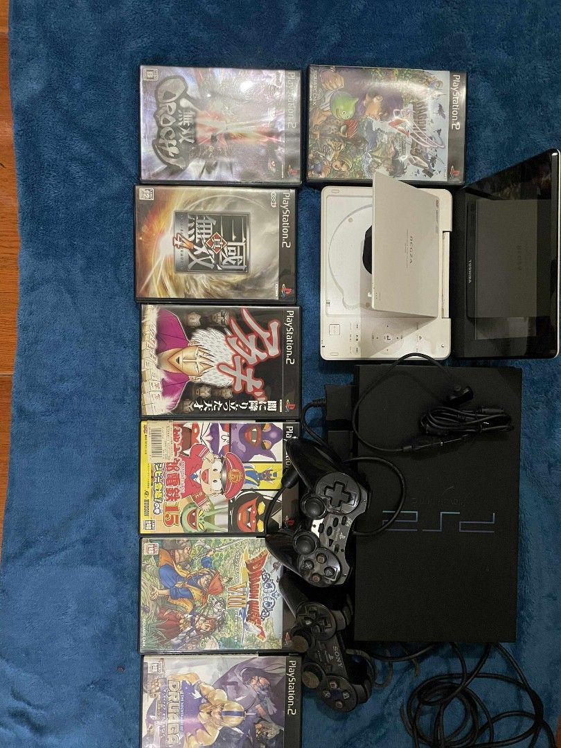 Sony PlayStation 2 Console with Games (Category: PlayStation) located in Manila. Submitted by jaceiz (Listing ID 1411310651, Image 1). Description: Includes a black Sony PlayStation 2 console, two controllers, and several games. Games include titles such as Dragon Quest V and VIII, Dynasty Warriors 4, and more. Also includes a white Toshiba portable DVD player. All items are as shown in the images..