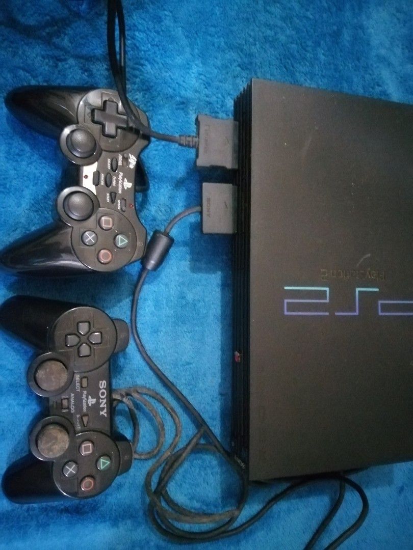 Sony PlayStation 2 Console with Games (Category: PlayStation) located in Manila. Submitted by jaceiz (Listing ID 1411310651, Image 2). Description: Includes a black Sony PlayStation 2 console, two controllers, and several games. Games include titles such as Dragon Quest V and VIII, Dynasty Warriors 4, and more. Also includes a white Toshiba portable DVD player. All items are as shown in the images..