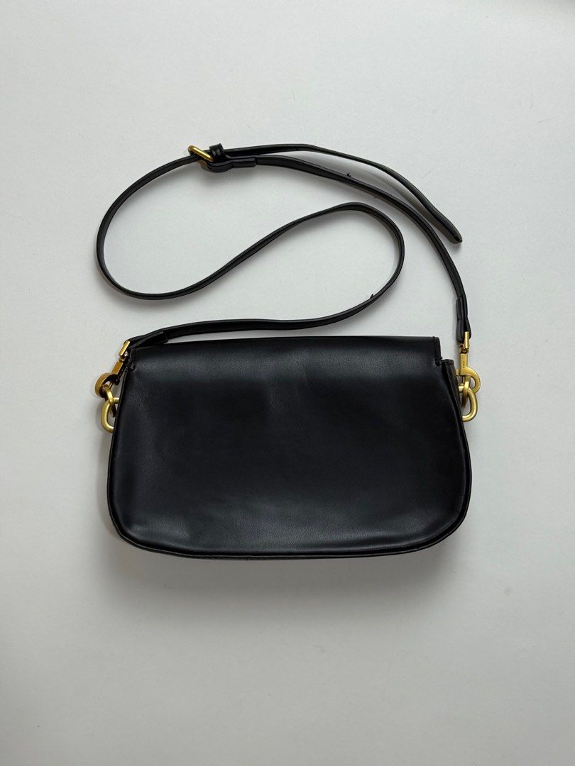 YSL Black Shoulder Bag (Category: Luxury Bags & Wallets) located in Manila. Submitted by eterna.luxe (Listing ID 1411421964, Image 2). Description: Black shoulder bag from Saint Laurent. Features a gold-tone YSL logo on the front. Includes a detachable shoulder strap and a zippered interior pocket. The interior is lined with black fabric and has a Saint Laurent logo embossed inside. The hardware is gold-toned, and the zipper pull is engraved with