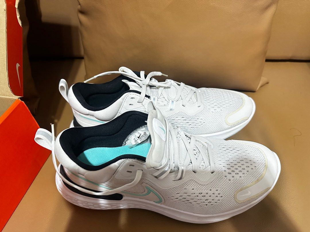 Nike Men’s Running Shoes (Category: Sneakers) located in Manila. Submitted by jaydeclutter (Listing ID 1411565515, Image 2). Description: - White Nike running shoes - Black and teal accents - Breathable mesh upper - Cushioned sole - Lace-up closure - Nike swoosh logo - Teal insole with Nike logo - Includes original box.