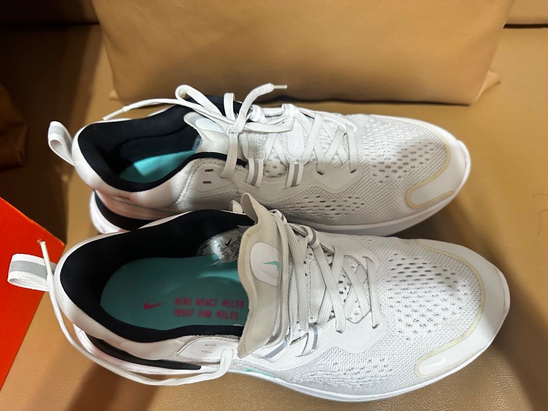 Nike Men’s Running Shoes (Category: Sneakers) located in Manila. Submitted by jaydeclutter (Listing ID 1411565515, Image 1). Description: - White Nike running shoes - Black and teal accents - Breathable mesh upper - Cushioned sole - Lace-up closure - Nike swoosh logo - Teal insole with Nike logo - Includes original box.