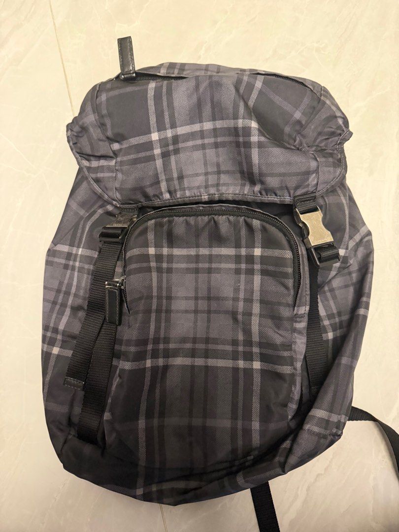 Prada Backpack （分類：手袋及銀包）位於 Hong Kong。 由 nojo2020 提交（商品編號 1411596113，圖片 3）。簡介： Prada backpack features a classic plaid pattern. It has a drawstring closure and a flap with buckles. The backpack has adjustable straps and a small front pocket. The interior features a Prada logo.。
