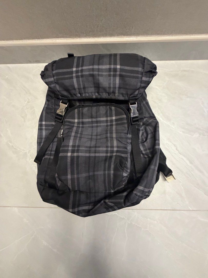 Prada Backpack （分類：手袋及銀包）位於 Hong Kong。 由 nojo2020 提交（商品編號 1411596113，圖片 1）。簡介： Prada backpack features a classic plaid pattern. It has a drawstring closure and a flap with buckles. The backpack has adjustable straps and a small front pocket. The interior features a Prada logo.。