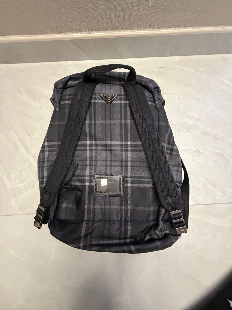Prada Backpack （分類：手袋及銀包）位於 Hong Kong。 由 nojo2020 提交（商品編號 1411596113，圖片 2）。簡介： Prada backpack features a classic plaid pattern. It has a drawstring closure and a flap with buckles. The backpack has adjustable straps and a small front pocket. The interior features a Prada logo.。