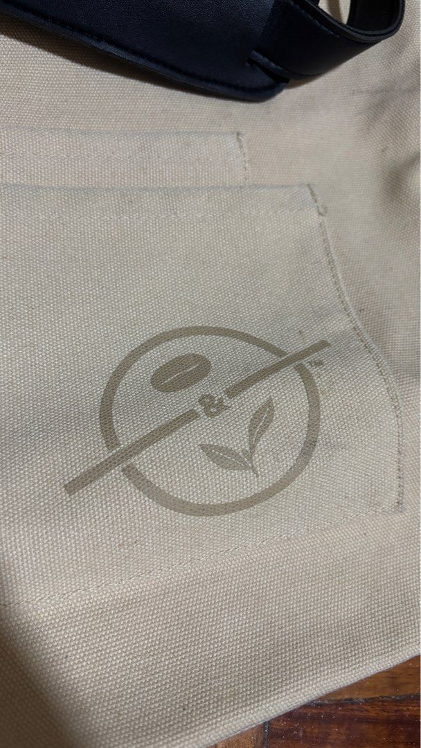 The Coffee Bean & Tea Leaf Unisex Multi-way Bag (Category: Tote Bags) located in Manila. Submitted by gingercat1111 (Listing ID 1411452892, Image 3). Description: - The Coffee Bean & Tea Leaf tote bag. - Beige canvas exterior. - Black straps. - Front pocket with brand logo. - Includes both shoulder straps and handles. - Interior with multiple pockets for organization..