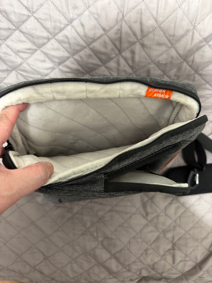 Tomtoc Defender Laptop Shoulder bag - 13 inch (Category: Laptop Bags & Sleeves) located in Pasig City. Submitted by vince.declutters (Listing ID 1411498722, Image 2). Description: Laptop bag features a padded interior and multiple compartments for storage. It includes a detachable shoulder strap for easy carrying. The bag has a handle with a brown leather accent. The bag has a zipper closure and a pocket on the front. - can fit a 13inch macbook -