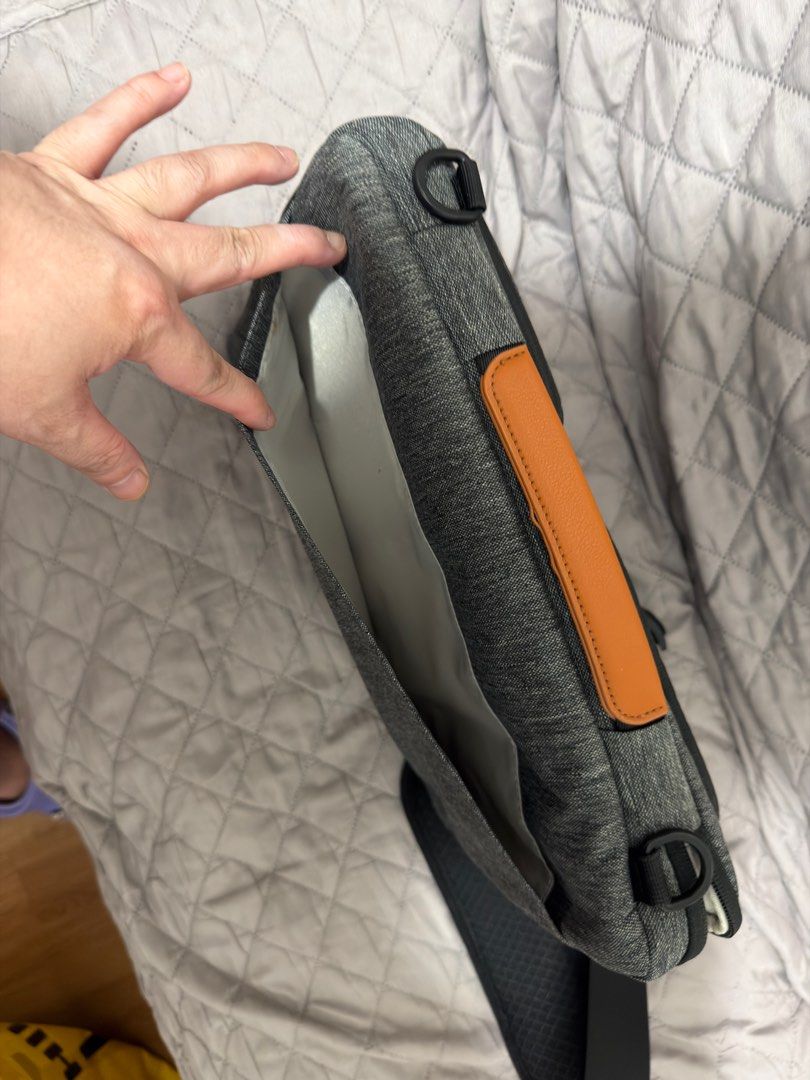 Tomtoc Defender Laptop Shoulder bag - 13 inch (Category: Laptop Bags & Sleeves) located in Pasig City. Submitted by vince.declutters (Listing ID 1411498722, Image 3). Description: Laptop bag features a padded interior and multiple compartments for storage. It includes a detachable shoulder strap for easy carrying. The bag has a handle with a brown leather accent. The bag has a zipper closure and a pocket on the front. - can fit a 13inch macbook -