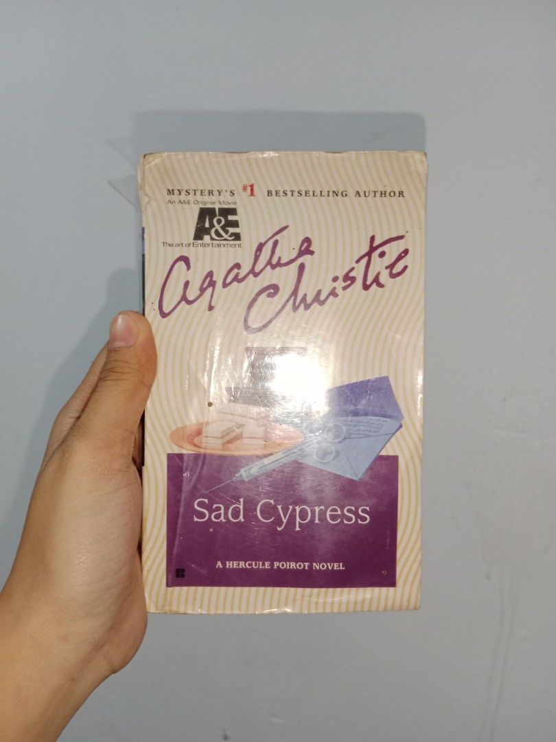 Agatha Christie Sad Cypress (Category: Storybooks) located in Sariaya. Submitted by variousbooks (Listing ID 1411767292, Image 1). Description: - Agatha Christie's 'Sad Cypress' novel. - Features Hercule Poirot. - Published by Penguin. - Distinctive purple and cream cover. - Includes a story summary on the back cover..