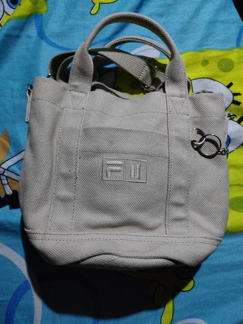 BTS X Fila Bucket Bag (Category: Cross-body Bags) located in Quezon City. Submitted by Cassidy (Listing ID 1411748467, Image 2). Description: - BTS Fila bucket bag - Beige canvas material - Drawstring closure - Top handle - Detachable shoulder strap - Interior pocket - BTS and Fila logo on front - Original Price 6000.