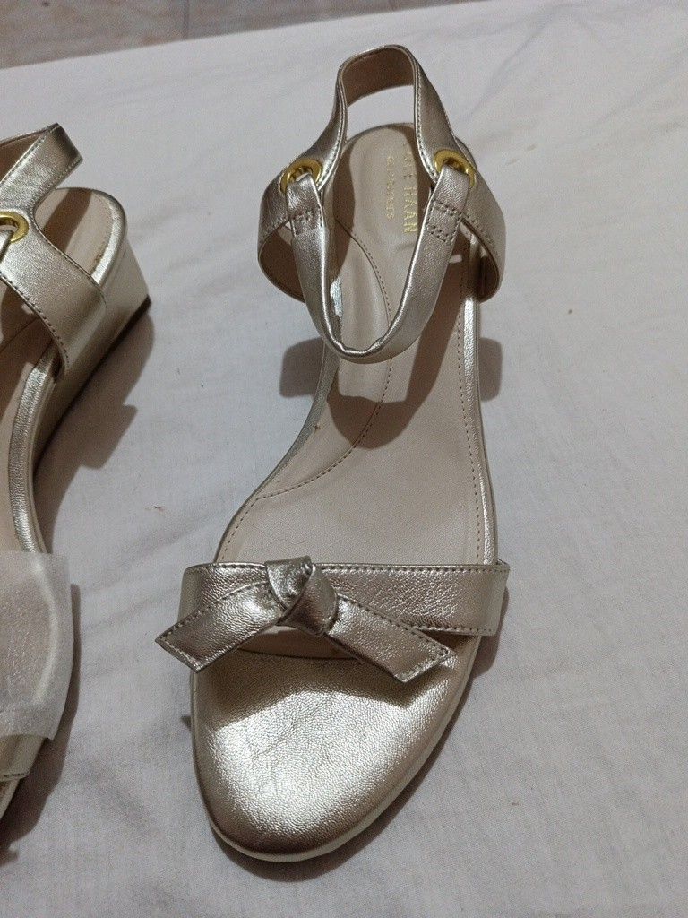 Cole Haan Josie Wedge Sandals (Category: Wedges) located in Pandi. Submitted by rizzahermo03052 (Listing ID 1411629613, Image 3). Description: - Cole Haan Josie Wedge Sandals - Gold color - Bow detail on front strap - Ankle strap - Wedge heel - Cole Haan branding on insole - Unworn condition.