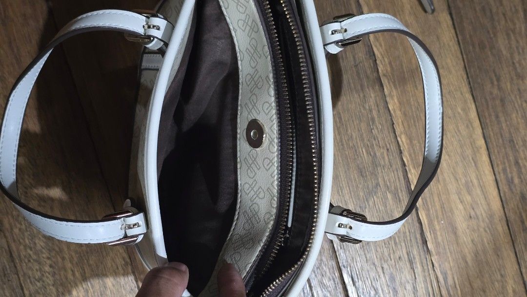 Hush Puppies patterned zippered shoulder bag in beige (Category: Shoulder Bags) located in Mandaluyong City. Submitted by joshlim (Listing ID 1411652673, Image 3). Description: Hush Puppies handbag features a beige and white color scheme with a patterned exterior. It includes a top zipper closure and a detachable shoulder strap. The interior has a brown lining and a small pocket. The bag has two handles and gold-colored hardware. The brand name i