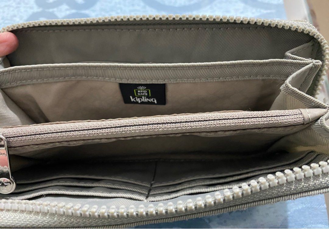 Kipling RFID Safe Wallet (Category: Wallets & Card holders) located in Cagayan de Oro. Submitted by cu_2022 (Listing ID 1411772519, Image 1). Description: - Kipling wallet with secure zip-around closure. - Multiple compartments and card slots for organization. - Includes a convenient wrist strap. - Features RFID protection for added security. - Interior zippered pocket for coins and small items. - Authentic Kipling design with the iconic logo..
