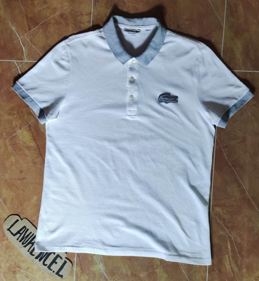 Lacoste Regular Fit Polo Shirt (Category: Tshirts & Polo Shirts ) located in Taguig. Submitted by lawrence_stuff (Listing ID 1411657447, Image 1). Description: - Authentic Lacoste polo shirt - Color: White with grey collar and cuffs - Features the iconic Lacoste crocodile logo - Made in Peru - Size: FR 4 / US M - Material: 100% cotton - Fit: Regular.