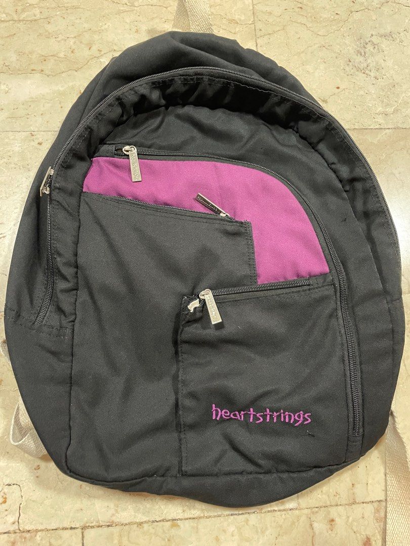 SKO-003 Heartstrings Black Backpack (Category: Backpacks) located in Manila. Submitted by iamspicy (Listing ID 1411645674, Image 1). Description: Buy at least 2 items from me to get discount. Payment first. Shipping fee shouldered by Buyer. No meetups. - Interior shows some stains - Black backpack with purple accent - Features multiple zippered compartments - Front pocket with "heartstrings" logo - Interior zippered pocket - Adjustable straps - P