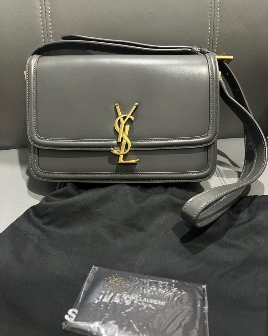 YSL Solferino Medium Satchel Bag (Category: Luxury Bags & Wallets) located in Del Monte. Submitted by my.personal.picks (Listing ID 1411717690, Image 1). Description: - Saint Laurent Solferino Medium Satchel Bag - Color: Grey - Iconic YSL logo in gold hardware - Includes dust bag and care card - Features a shoulder strap - Rectangular shape - Smooth leather.