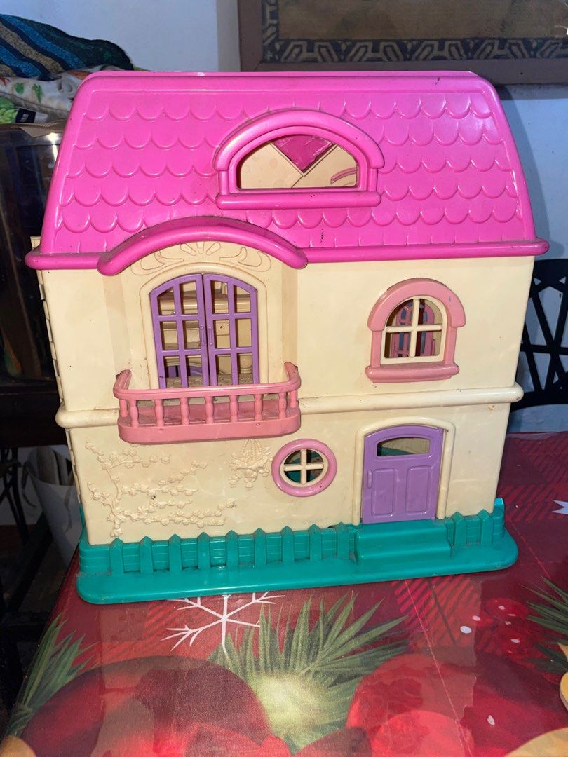 Big Dollhouse (Category: Kids Toys) located in Manila. Submitted by itsmedex (Listing ID 1411849982, Image 2). Description: - Two-story dollhouse with a charming design. - Features a pink roof and beige exterior. - Includes a teal base and pink accents. - Multiple windows and doors. - Opens up to reveal several rooms, including a kitchen. - Comes with a balcony for added play value..