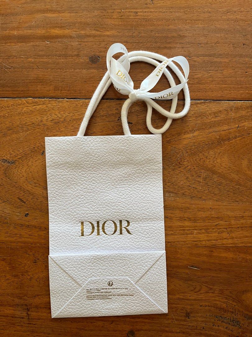 Dior Gift Bag with Ribbon (Category: Luxury Bags & Wallets) located in Las Pinas. Submitted by southofmanila (Listing ID 1411792774, Image 1). Description: - Authentic Dior gift bag - White textured exterior - Gold Dior logo - Includes white ribbon - White rope handles - Small bee emblem inside - Approximately 10cm wide x 15cm tall.