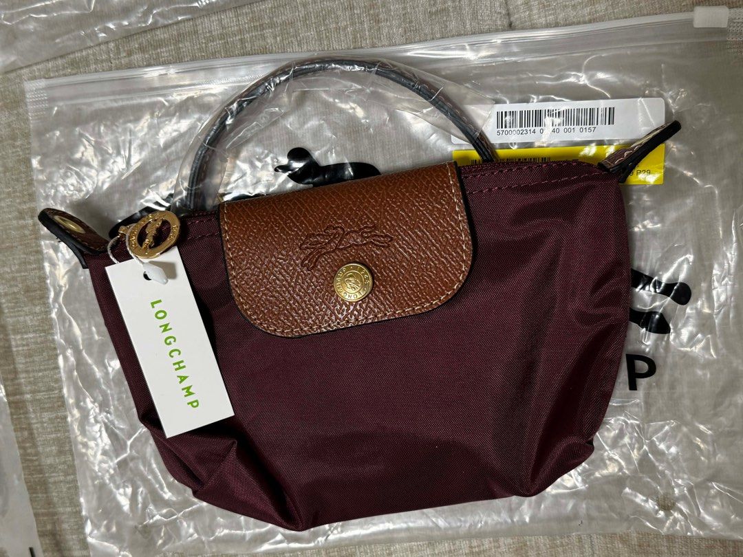 Longchamp Le Pliage Cuir Handbag (Category: Luxury Bags & Wallets) located in San Mateo. Submitted by darlynlaguna (Listing ID 1411827603, Image 1). Description: - Brand new Longchamp Le Pliage Cuir handbag - Color: Deep burgundy - Features a classic brown leather flap with Longchamp logo - Includes a top handle - Comes with original tag - Unused and still in original packaging.