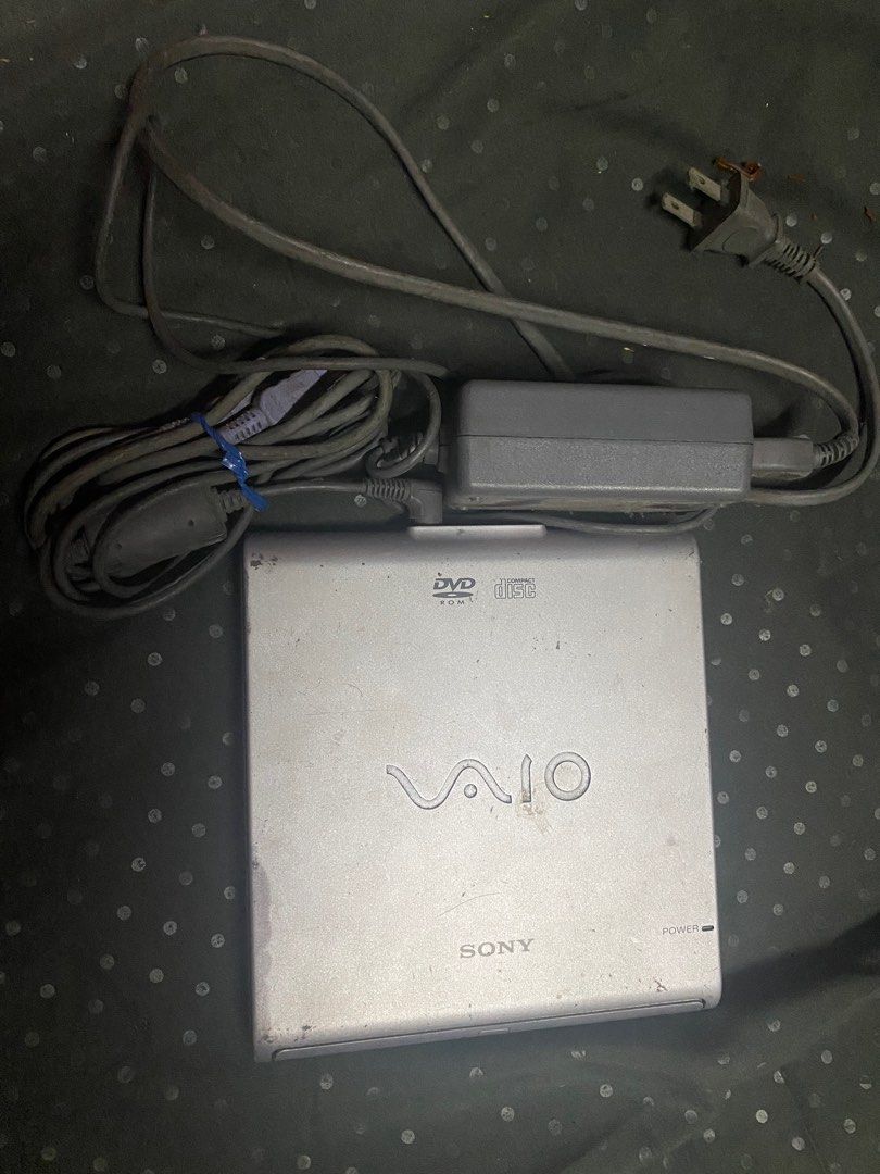 Sony VAIO PCGA-DVD1 DVD-ROM Drive (Category: Laptops & Notebooks) located in Manila. Submitted by olxph_540542159 (Listing ID 1411794097, Image 1). Description: - Sony VAIO PCGA-DVD1 DVD-ROM Drive - Includes the drive and power adapter - Features a stylish silver finish - VAIO logo is prominently displayed - Portable DVD-ROM drive.
