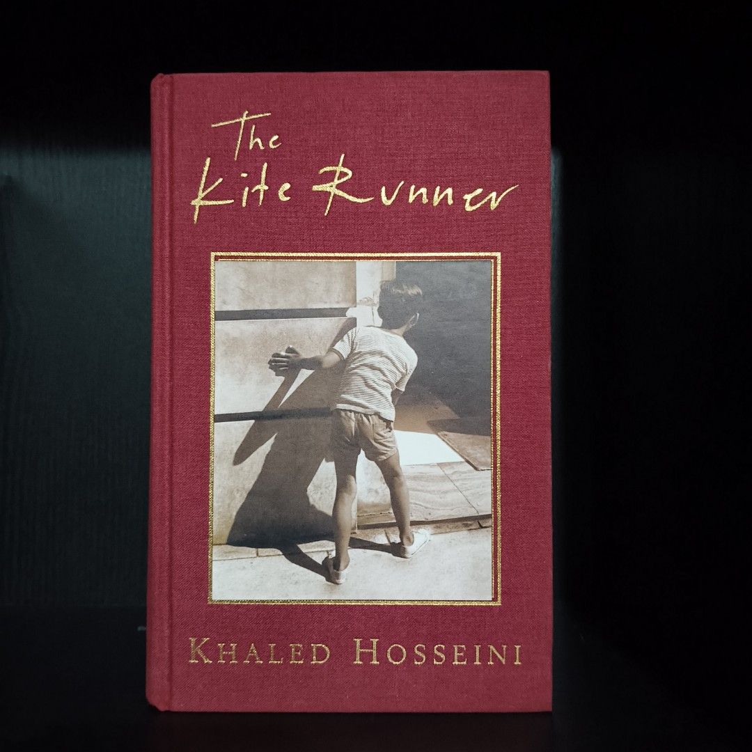 the kite runner (hardcover) khaled hosseini (Category: Storybooks) located in Rosales. Submitted by leejonli2 (Listing ID 1411924918, Image 1). Description: - "The Kite Runner" by Khaled Hosseini - Red cover with gold lettering - Features a boy on the cover - Clean pages and sturdy binding - A compelling and engaging story.