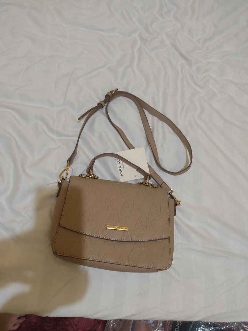 Anne Klein Embossed Logo Crossbody Bag (Category: Cross-body Bags) located in Cavite. Submitted by perfectfinds (Listing ID 1412113526, Image 1). Description: - Anne Klein crossbody bag - Neutral beige color - Embossed logo design - Top handle and chain swag - Main compartment with multiple pockets - Detachable strap for versatile carrying Bought for my self for approximately 2,500. never used it. .