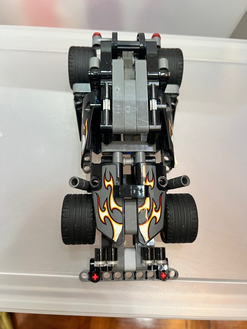 Lego Technic Hot Rod Car (Category: Lego & Building Sets) located in Pasig City. Submitted by theclosetcasemanila (Listing ID 1412030379, Image 3). Description: - Lego Technic Hot Rod - Hot rod design with flame and skull decals - Black tires with gold rims - Primarily black and gray color scheme - Detailed model with visible mechanical components.