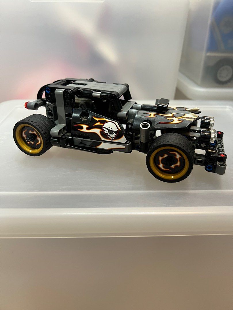 Lego Technic Hot Rod Car (Category: Lego & Building Sets) located in Pasig City. Submitted by theclosetcasemanila (Listing ID 1412030379, Image 1). Description: - Lego Technic Hot Rod - Hot rod design with flame and skull decals - Black tires with gold rims - Primarily black and gray color scheme - Detailed model with visible mechanical components.