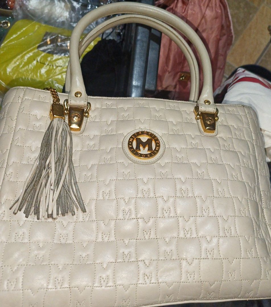 Metrocity Cream Handbag with Tassel (Category: Luxury Bags & Wallets) located in Rizal. Submitted by judithtillo19 (Listing ID 1412046159, Image 1). Description: Cream-colored Metrocity handbag with quilted design. Features gold hardware, tassel detail, and a back zippered pocket. Includes two handles. Some stain inside but it doesn't affect the beauty of the bag....Ready to use, already sanitized .