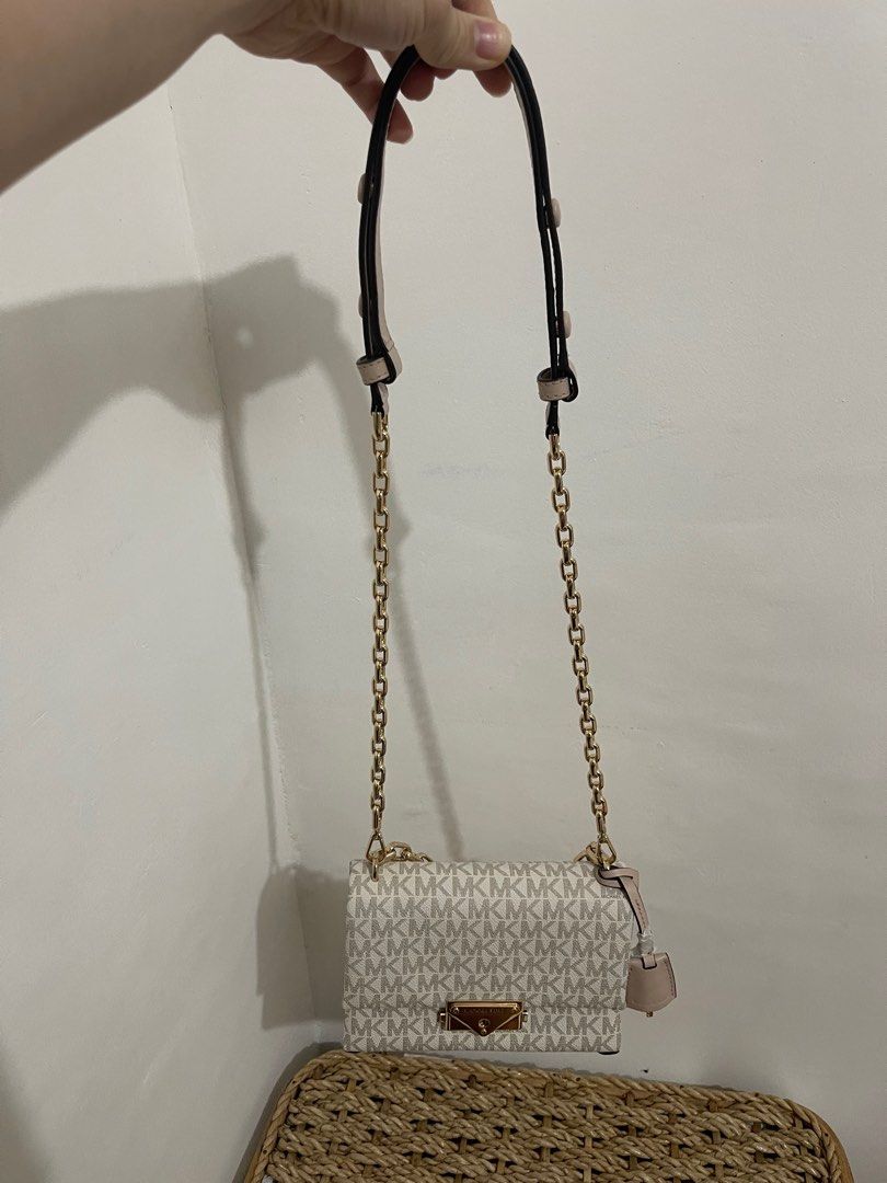 Michael Kors Cece Chain Shoulder Bag (Category: Luxury Bags & Wallets) located in Caloocan City. Submitted by gazellection.shop (Listing ID 1412112683, Image 2). Description: Authentic Michael Kors Cece Chain Shoulder Bag. Features a gold-tone chain strap and a flap closure with the Michael Kors logo. The bag has a beige and white MK logo pattern. Includes a dust bag and original tags. The interior has a pocket for cards..
