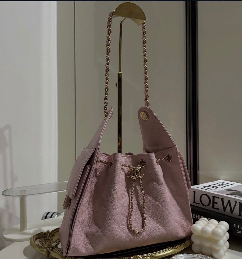 PREMIUM Chanel Pink Drawstring Handbag (Category: Luxury Bags & Wallets) located in Del Monte. Submitted by thingsidontuse (Listing ID 1412131018, Image 1). Description: - Chanel handbag - Soft pink color - Drawstring closure - Chain strap - Quilted design - Flap pocket with CC logo - Gold-tone hardware - Interior pocket with Chanel label - microchip .