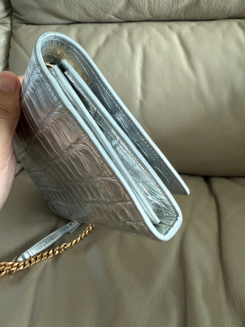 Saint Laurent Silver Croc-Embossed Wallet on Chain (Category: Luxury Bags & Wallets) located in Makati City. Submitted by markussangabriel (Listing ID 1412102651, Image 3). Description: - Saint Laurent wallet on chain - Silver color - Croc-embossed finish - Gold chain strap - Multiple interior compartments - Snap closure - Saint Laurent logo on front Comes with authentication certificate from Entrupy :) Feel free to send your best offer..