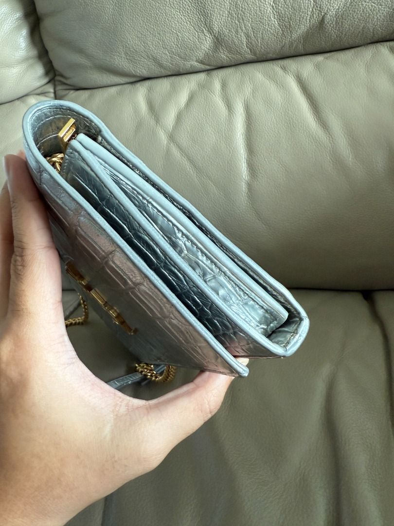 Saint Laurent Silver Croc-Embossed Wallet on Chain (Category: Luxury Bags & Wallets) located in Makati City. Submitted by markussangabriel (Listing ID 1412102651, Image 2). Description: - Saint Laurent wallet on chain - Silver color - Croc-embossed finish - Gold chain strap - Multiple interior compartments - Snap closure - Saint Laurent logo on front Comes with authentication certificate from Entrupy :) Feel free to send your best offer..
