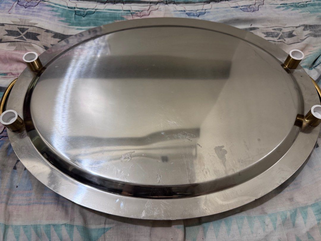 Stainless Steel Oval Serving Tray (Category: Other Kitchenware & Tableware) located in Manila. Submitted by decluterthings888 (Listing ID 1412137919, Image 1). Description: - Oval stainless steel serving tray - Features gold-colored handles - Includes four white feet - Approximately 18 inches in length - Ideal for serving food or displaying items - A stylish and practical home addition.