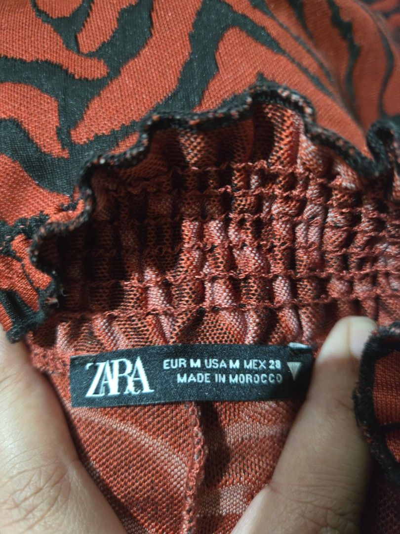 Zara Red Tiger Print Dress (Category: Dresses) located in Makati City. Submitted by abcd2020. (Listing ID 1412009019, Image 2). Description: - Zara dress with a bold red and black tiger print - Size S to M (as per label) - Features a stylish ruffled hem - Gathered neckline adds a flattering touch - Made in Morocco.