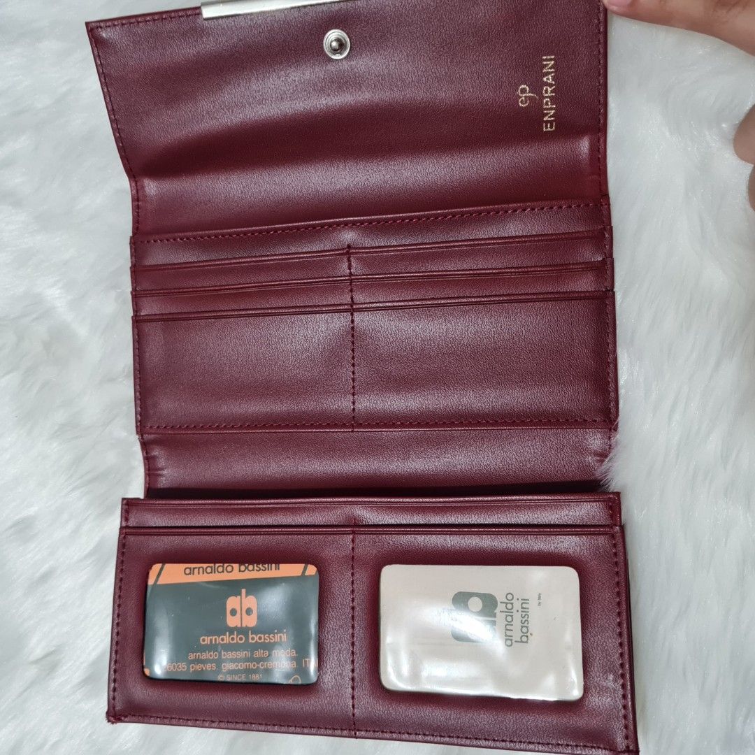 Arnaldo Bassini long wallet (Category: Clutches) located in Cavite. Submitted by iammil (Listing ID 1412253296, Image 3). Description: Arnaldo Bassini long wallet (wine red color). LP is 200. Condition: 9/10 Normal signs of use such as: -Minimal hairline scratches in the hardwares -Cracks on the folded areas (common signs of use) Overall, leather condition is good. No sticky parts..
