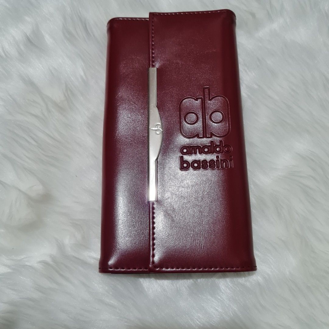 Arnaldo Bassini long wallet (Category: Clutches) located in Cavite. Submitted by iammil (Listing ID 1412253296, Image 1). Description: Arnaldo Bassini long wallet (wine red color). LP is 200. Condition: 9/10 Normal signs of use such as: -Minimal hairline scratches in the hardwares -Cracks on the folded areas (common signs of use) Overall, leather condition is good. No sticky parts..