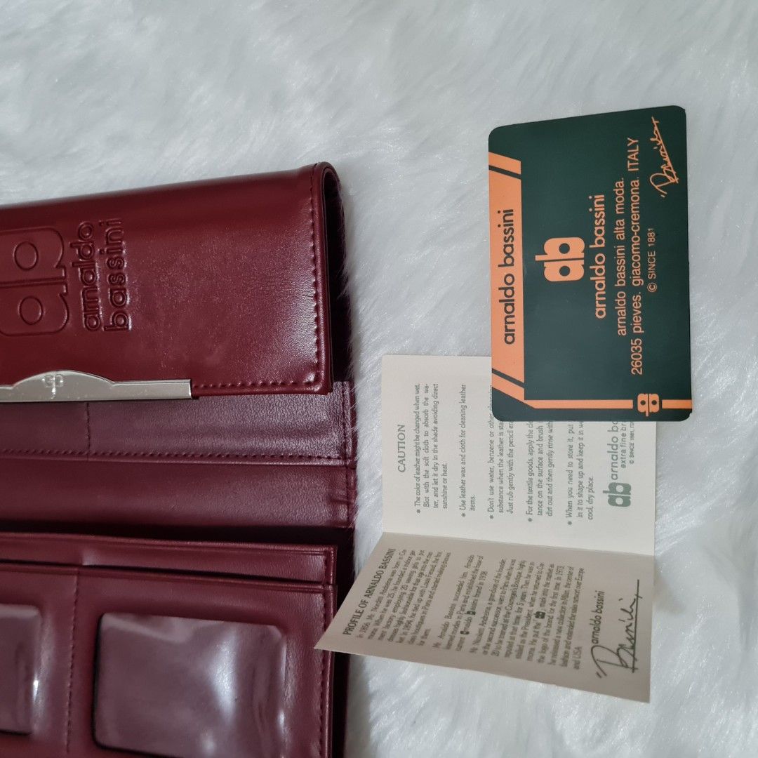 Arnaldo Bassini long wallet (Category: Clutches) located in Cavite. Submitted by iammil (Listing ID 1412253296, Image 2). Description: Arnaldo Bassini long wallet (wine red color). LP is 200. Condition: 9/10 Normal signs of use such as: -Minimal hairline scratches in the hardwares -Cracks on the folded areas (common signs of use) Overall, leather condition is good. No sticky parts..