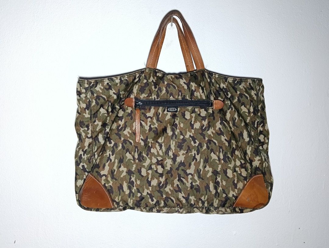 Division Rei Camouflage Tote Bag (Category: Tote Bags) located in Klang. Submitted by ediey_murayama (Listing ID 1412330281, Image 1). Description: - Camouflage pattern tote bag - Leather handles and accents - Secure zipper closure - Spacious interior - Includes Division Rei tag - Dimensions: Approximately 45cm (width) x 35cm (height) - Leather patches on bottom corners.
