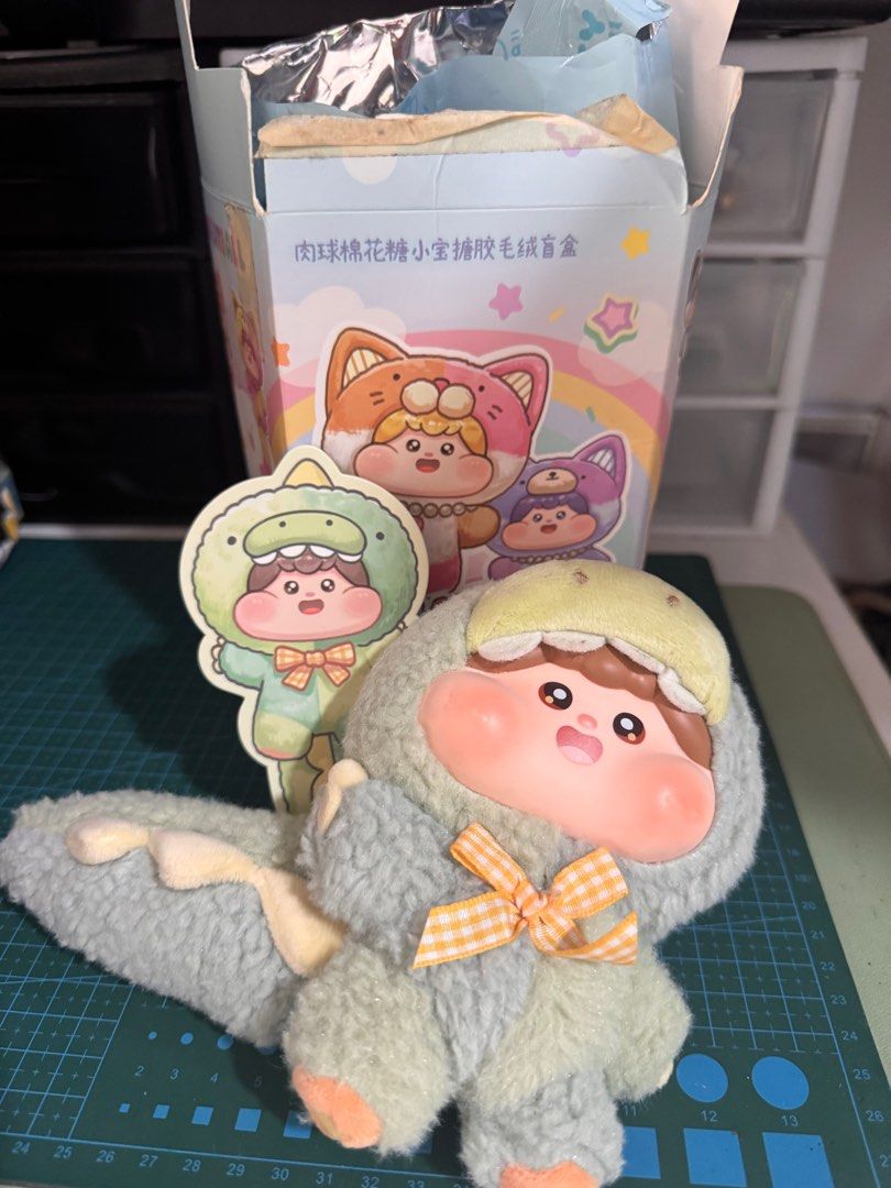 Fluffy Meatball Dino (Category: Plushies & Soft Toys) located in Paranaque City. Submitted by babsdeclutter (Listing ID 1412255433, Image 1). Description: - Adorable plush blind box figure - Features a cute outfit and bow - Unique design - Collectible item - Box with Chinese characters - Likely a limited edition.