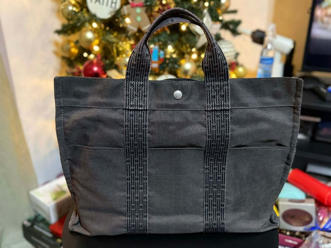Hermes Herbag Tote Bago (Category: Luxury Bags & Wallets) located in Pasig City. Submitted by llopez (Listing ID 1412266104, Image 2). Description: - Authentic Hermes Herbag Tote Bag - Stylish grey and black checkered pattern - Features a top handle - Secure zipper closure and lock - Interior with black lining and Hermes label - Exterior pockets with snap closure - Silver-toned hardware.